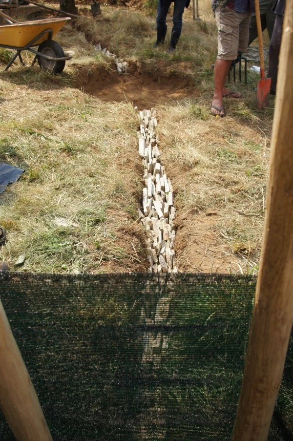 Vue depuis l'intérieur de la tour. Les drains conduisant les excès d'eau en hiver, sont crées à partir de pierres de récupération. Une couche horizontales, un assemblage vertical ensuite, pour faciliter l'écoulement des eaux, puis une nouvelle couche horizontale, pour éviter le colmatage. Il conduiront les trop plein vers des bassins de mulchs, plantés de guildes de végétaux comestibles et utiles.