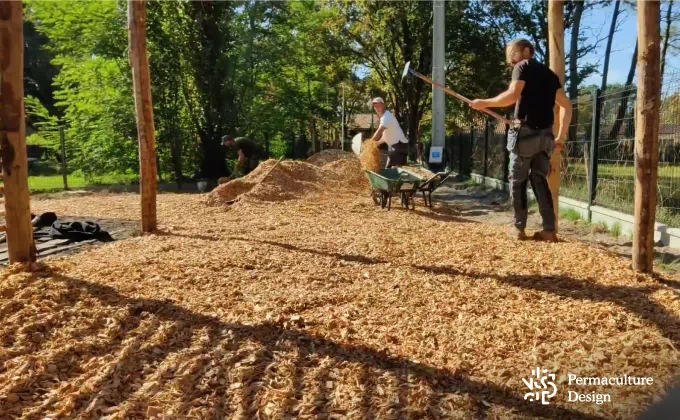 Allée en copeaux de bois dans jardin en permaculture.