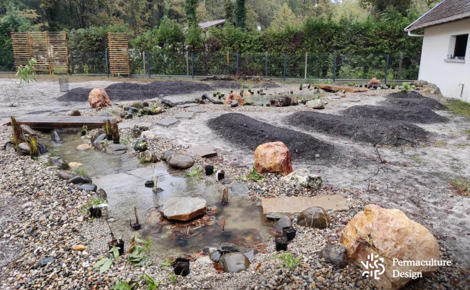 Potager en mandala autour d'une mare en permaculture.