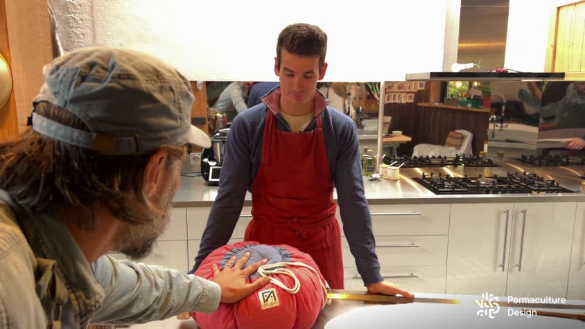 Christophe touche la marmite norvégienne fermée contenant un plat chauffé à 100 °C pour constater que ça ne brule pas du tout sur l’extérieur.